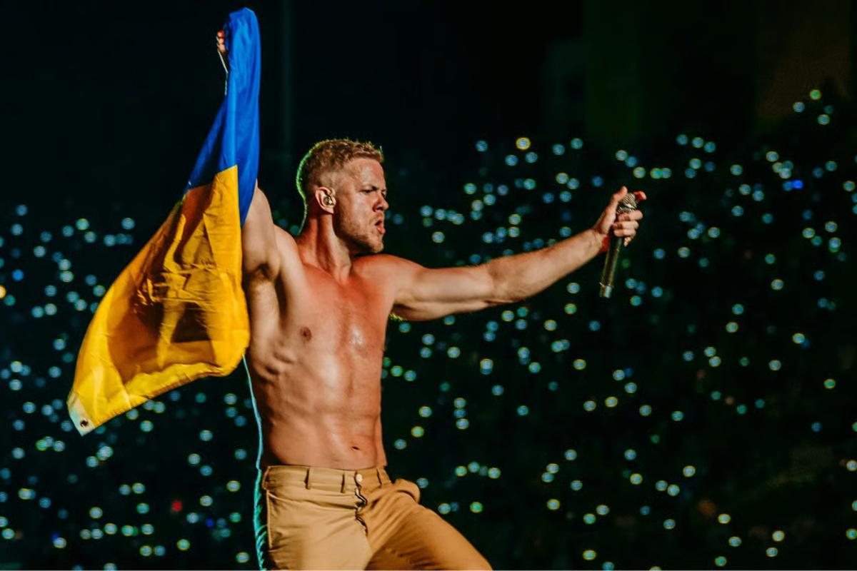 Imagine Dragons с украинским флагом / Кадр из видео Скандал в Варшаве: почему запретили украинский флаг на Imagine Dragons - сеть кипит