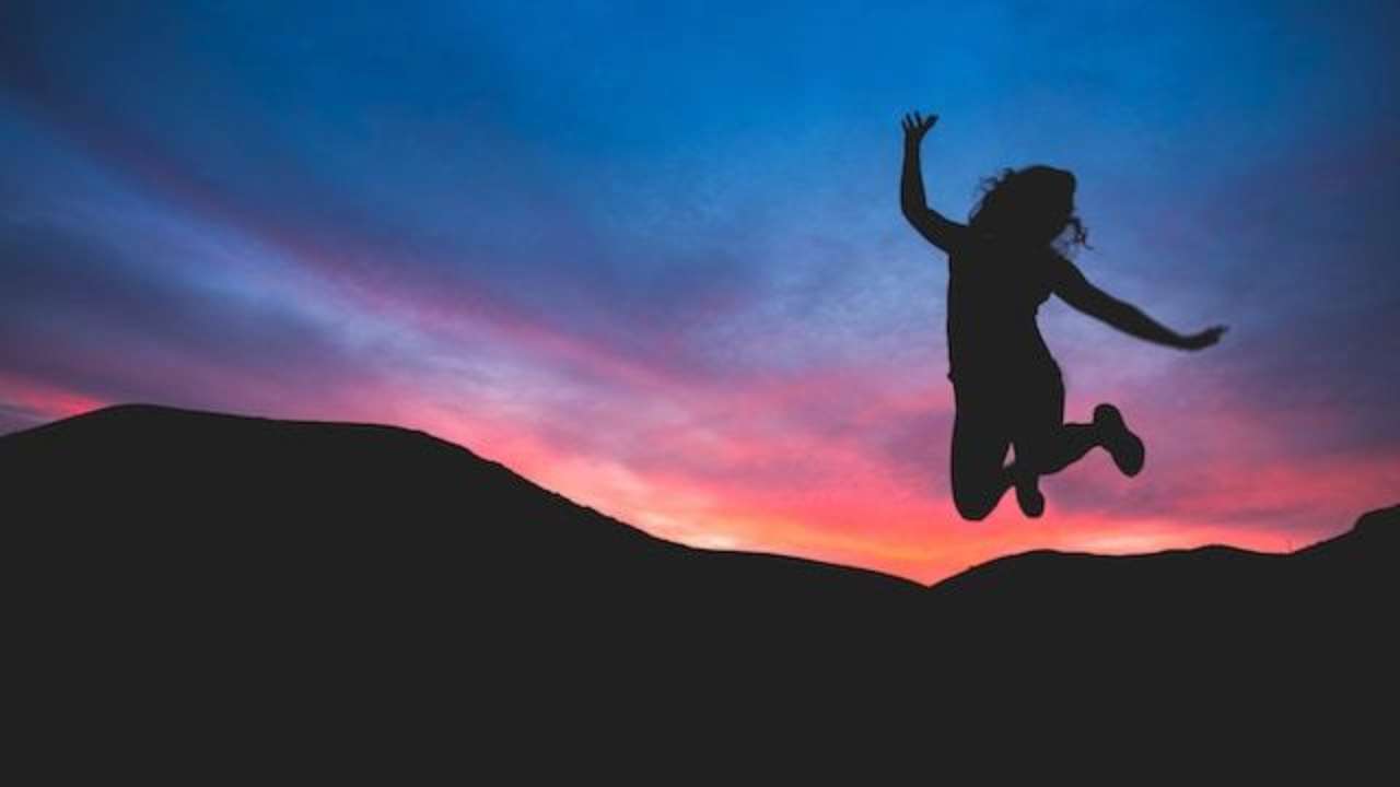 Обладатели каких имен празднуют День ангела 20 июля/Фото: Austin Schmid/Unsplash Женщина прыгает в вечерних горах