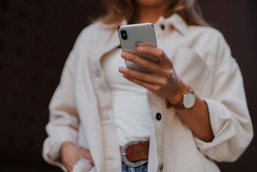 Як переглядати сторіс в Instagram анонімно/Фото: Jenny Ueberberg/Unsplash Жінка зі смартфоном у руках