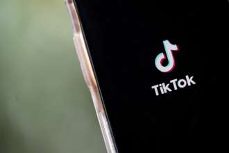 Соцсети TikTok грозит $30 миллионов штрафа из-за недостаточной защиты детей/Фото: Drew Angerer/Getty Images Логотип соцсети TikTok на экране смартфона