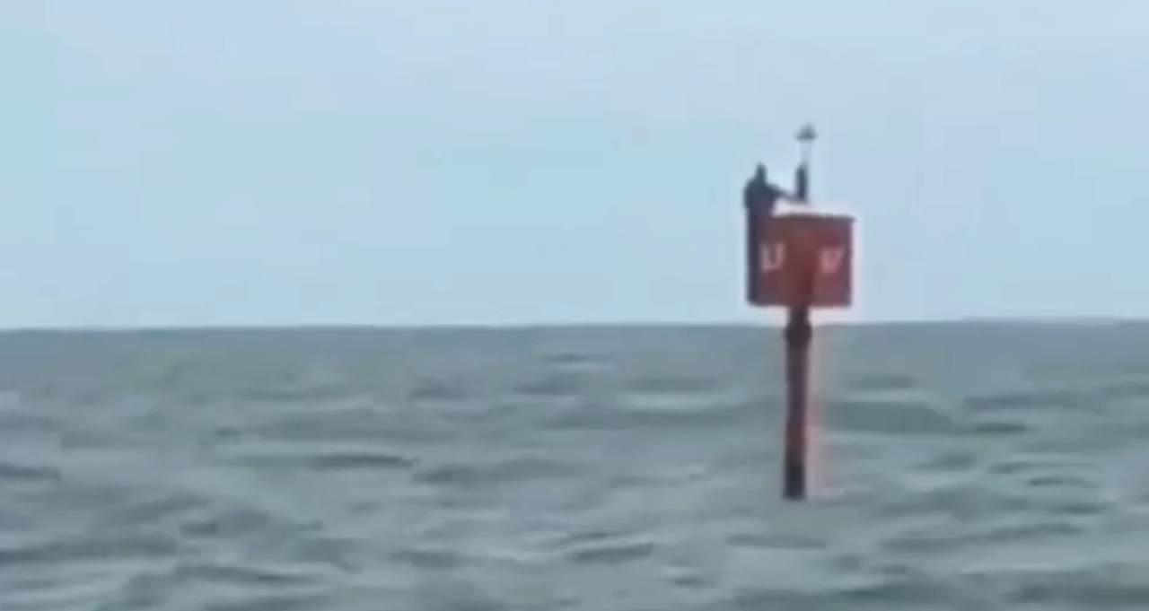 Человек на сигнальном буе посреди океана
