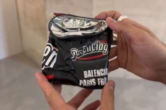Новый кошелек от Balenciaga в виде пожмаканной пачки чипсов / Скриншот из видео Модники в шоке: Balenciaga презентовала новый кошелек в виде скомканной пачки чипсов