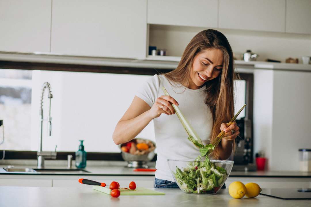 Названы продукты, которые ускоряют метаболизм / Фото Freepik Женщина готовит салат на кухне