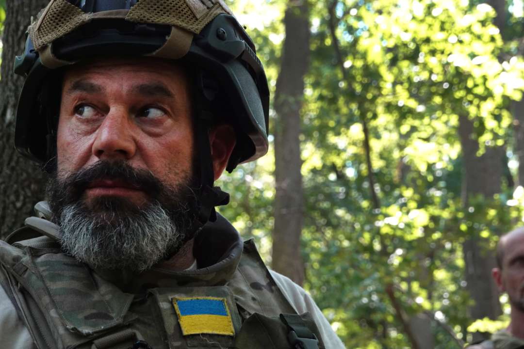 Украинский военный в шлеме и бронежилете стоит в лесу
