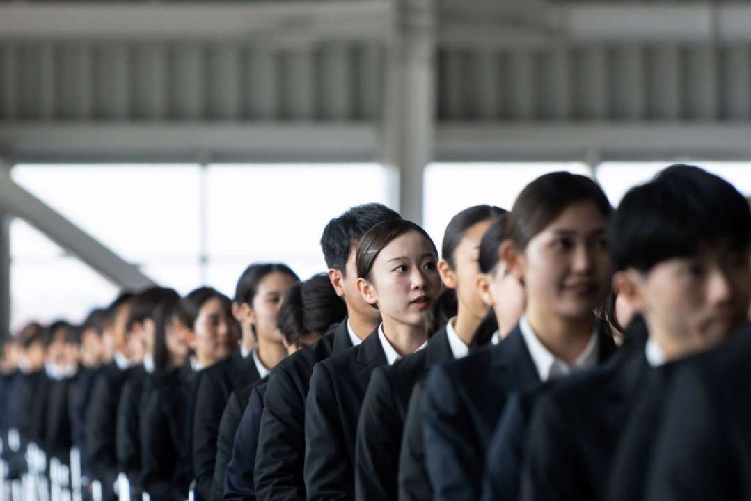 Всі Японці можуть мати однакове прізвище через 500 років/Фото: Tomohiro Ohsumi/Getty Images Японці в однаковій формі стоять один за одним